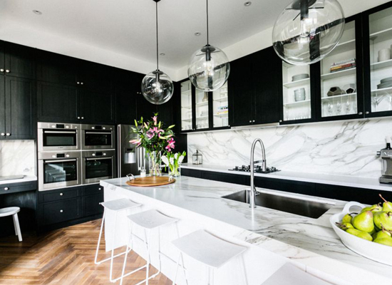 These black kitchen cabinets are the perfect complement to the marble walls and surfaces