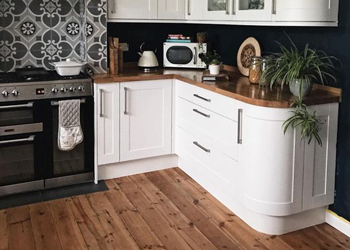 This kitchen matches the solid wood worktops with the kitchen flooring material.