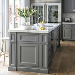 A grey kitchen with a slightly different shade of grey on the island and cabinets