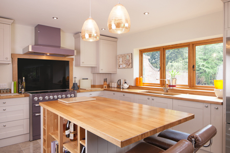 This solid oak kitchen features Shaker doors painted in Farrow & Ball's Elephants Breath.