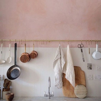 Dappled pink kitchen walls offer a striking effect, especially when set against white tiles.