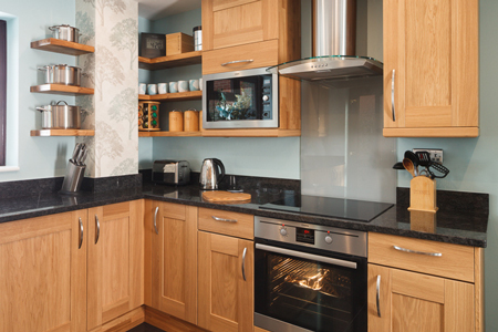 This kitchen has a black sparkle laminate worktop and unpainted Shaker doors.