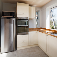 Stainless steel appliances in an open plan, neutral kitchen