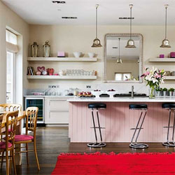 A traditional kitchen with a wooden island painted in Farrow & Ball’s Calamine pink