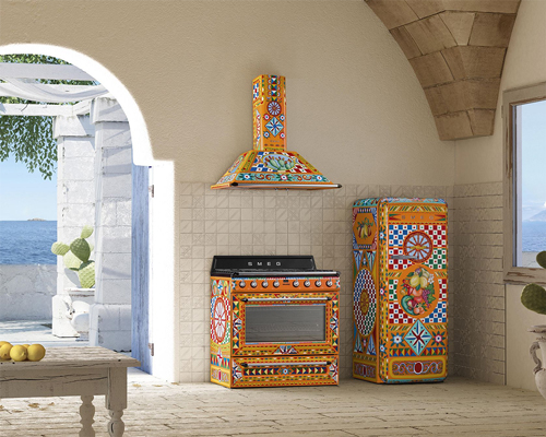 An open Mediterranean kitchen with an extremely vibrant Smeg fridge, oven and hood