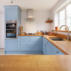 A wooden kitchen with pale blue cabinets and stainless steel appliances