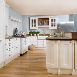 A bright kitchen with white cabinets and mis-matched worktops