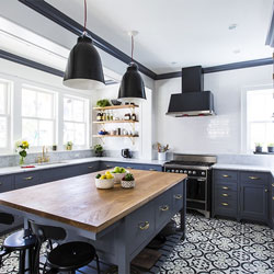 A patterned floor makes a statement in this kitchen with dark blue cabinetry and bright white walls.