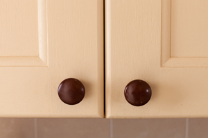 Cream painted oak cabinet doors with wooden knobs.