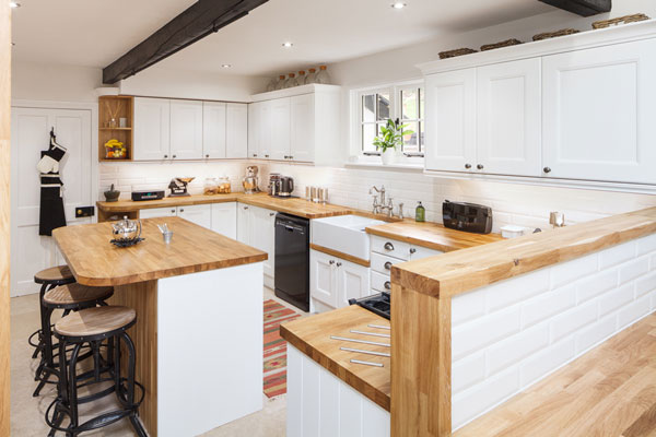 This farmhouse kitchen has a contemporary twist created through the stark contrast the All White frontals used next to the solid oak worktops
