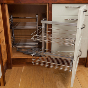 Handy wirework storage solutions help to keep solid wood kitchens uncluttered.