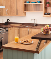 Kitchen island with oak cabinets, full stave Prime Oak worktop and breakfast bar.