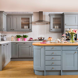 A kitchen featuring a blue island and grey cabinets