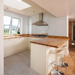 A neutral kitchen with breakfast bar, skylight and a countryside view