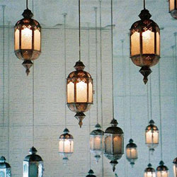 Many Moroccan-style pendant lamps hanging from a ceiling