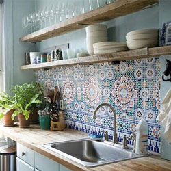 A light-coloured wooden kitchen with Moroccan tiles and a feature wall