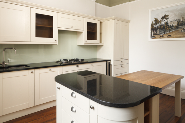This kitchen contrasts the natural grain of wood against the high gloss work surfaces and glass splashbacks.
