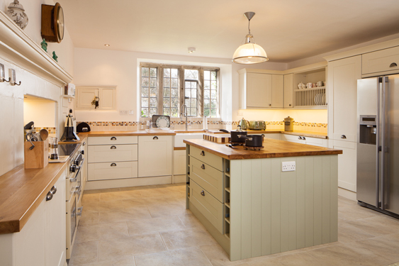 Here, gorgeous oak worktops are paired with cabinet frontals in Farrow & Ball’s Clunch and Vert De Terre.