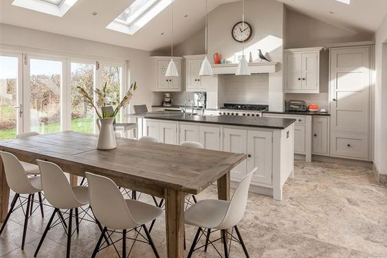 This open plan kitchen diner makes the most of the light coming in from the patio doors and skylights, creating a bright, airy space