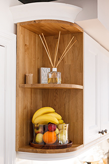 An open curved corner wall cabinet is the perfect place for a fruit bowl in oak kitchens