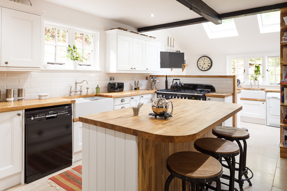 Oak worktops are teamed with white cabinets and end panels in this beautiful solid wood kitchen.