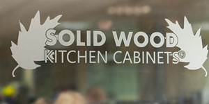 Solid Wood Kitchen Cabinets logo on a glass door