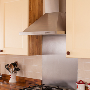 Stainless steel splashbacks bounce light back into solid wood kitchens.