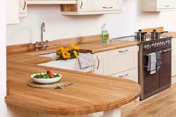 A traditional wood kitchen with a bowl of salad on the worktop