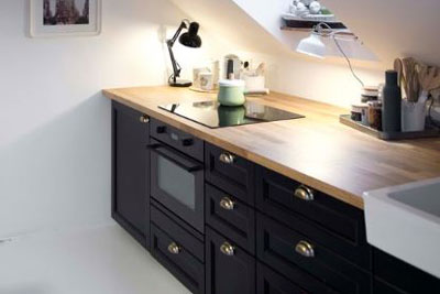 This small contemporary monochrome kitchen features black shaker doors.