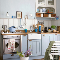 Delicate blue wooden cabinet frontals with tongue and groove paneling creates a relaxing seaside-inspired kitchen.