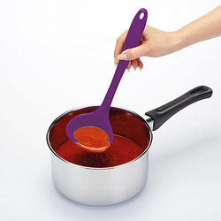 A person mixing soup with a bright purple spoon
